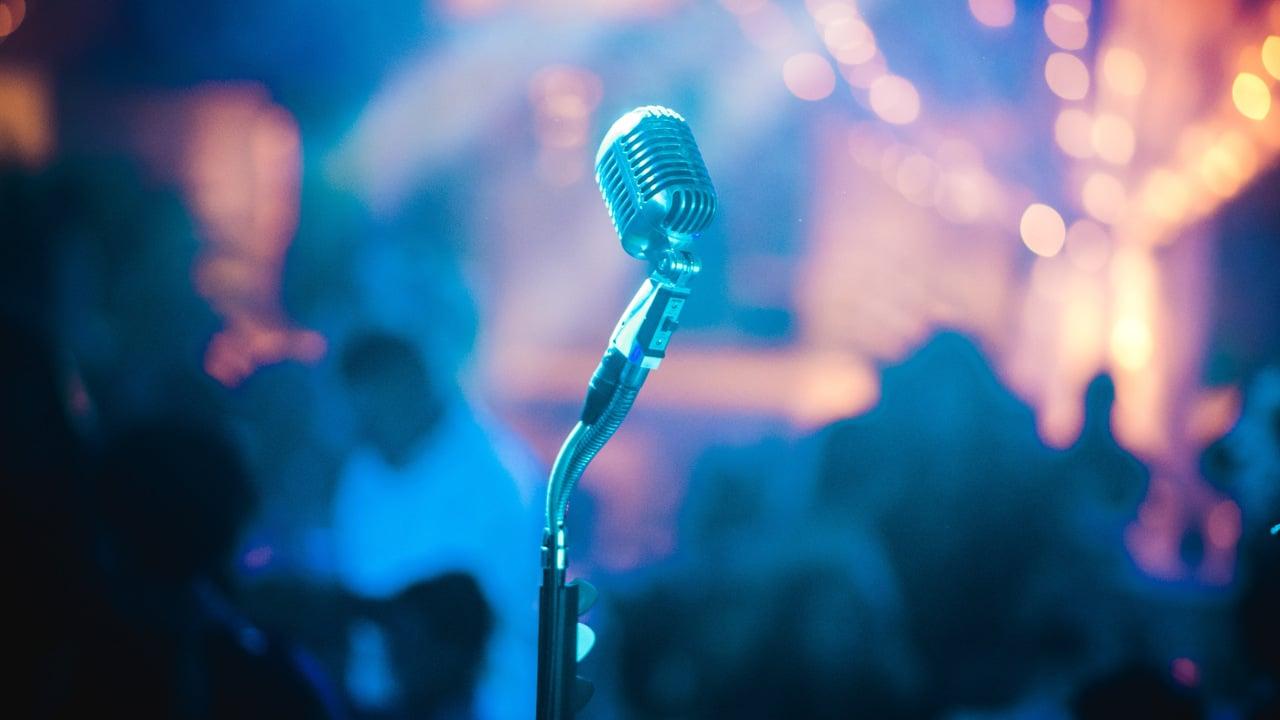 En ensam mikrofon på en scen med oskarp bakgrund