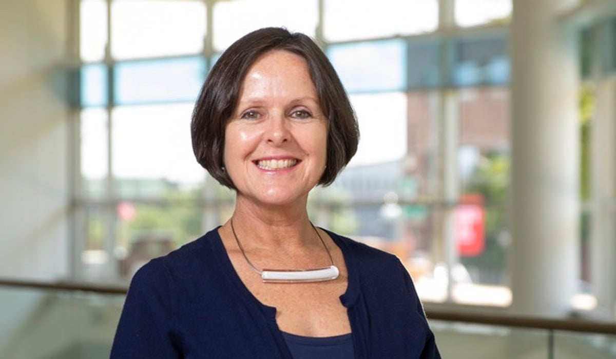 En kvinna står framför en glasvägg.