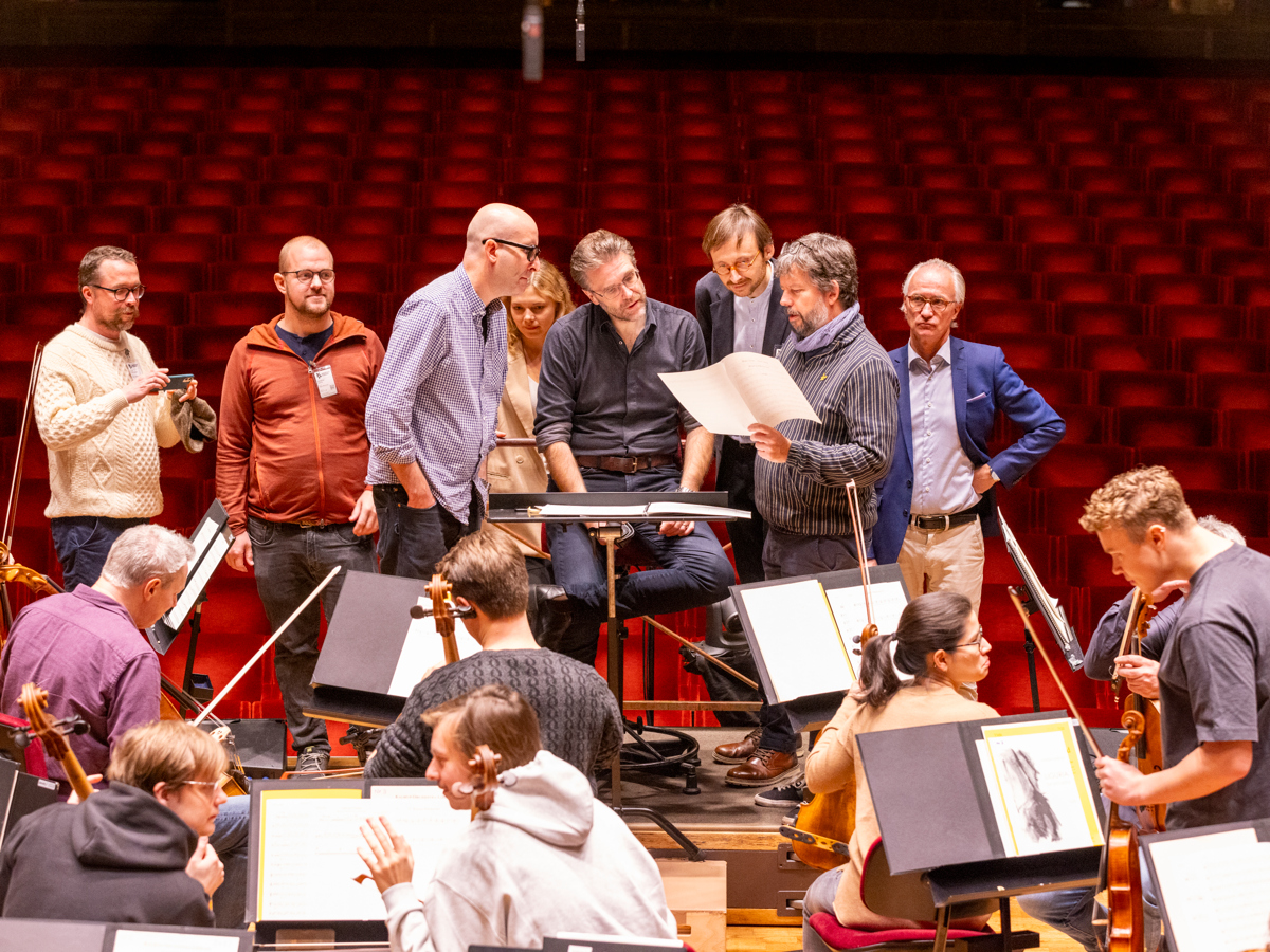 Grupp människor på podiet framför Kungliga Filharmonikerna.