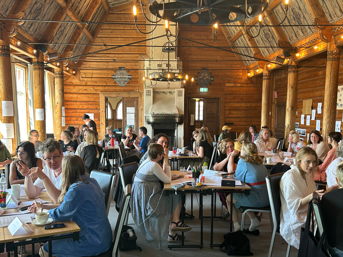 Deltagarna samtalar kring bord i konferenslokalen.