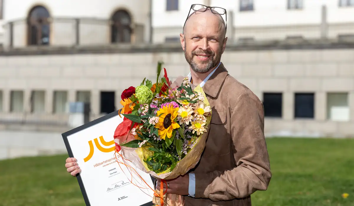 Foto på Finn Filén som håller i blommor och diplom