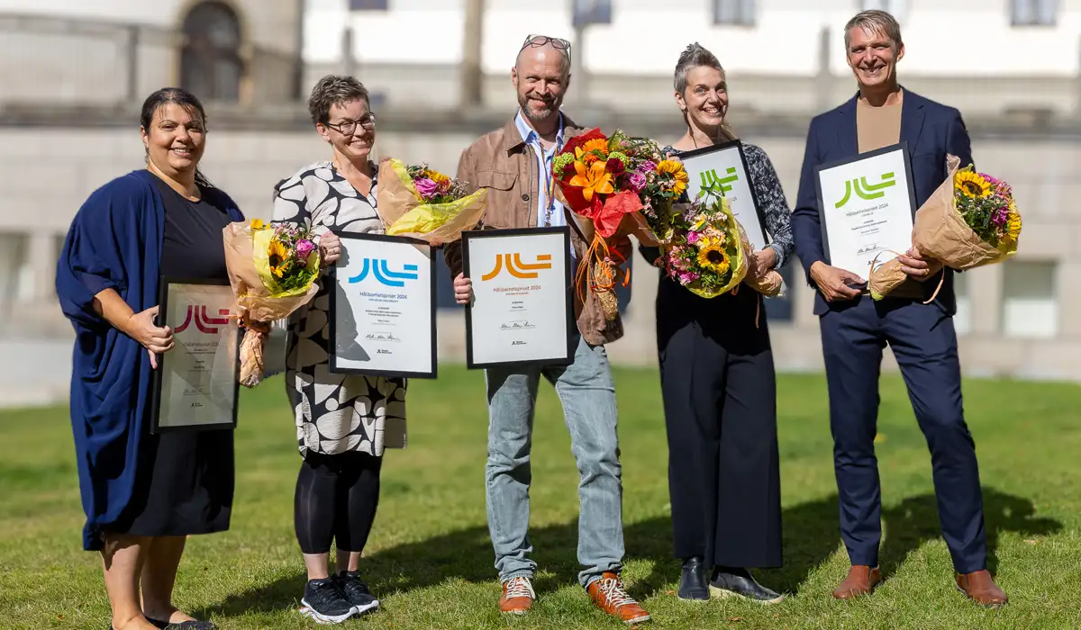 Foto på vinnarna av hållbarhetspriset. De håller i blommor och diplom