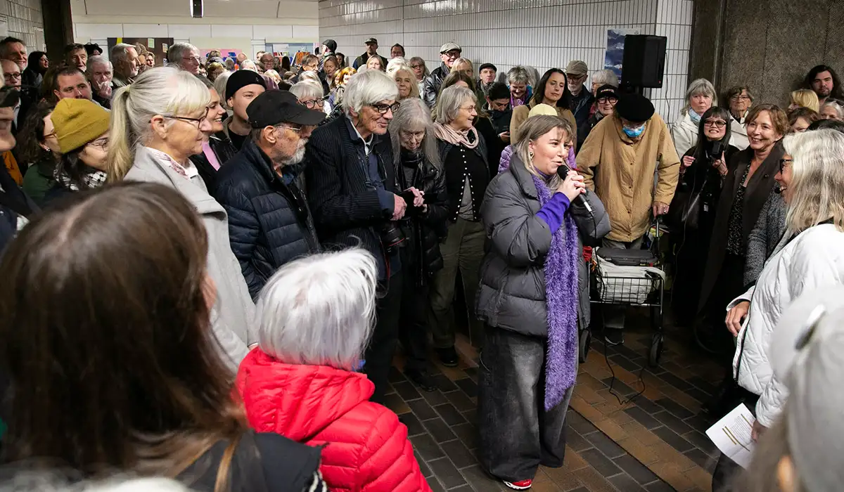 Stor folksamling på Gärdet med Amanda i mitten med en mikrofon.