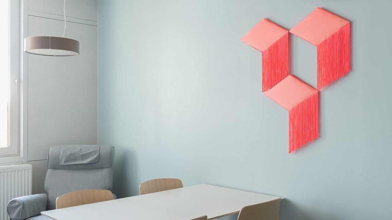 textil skulptur i geometrisk form på vägg framför matbord