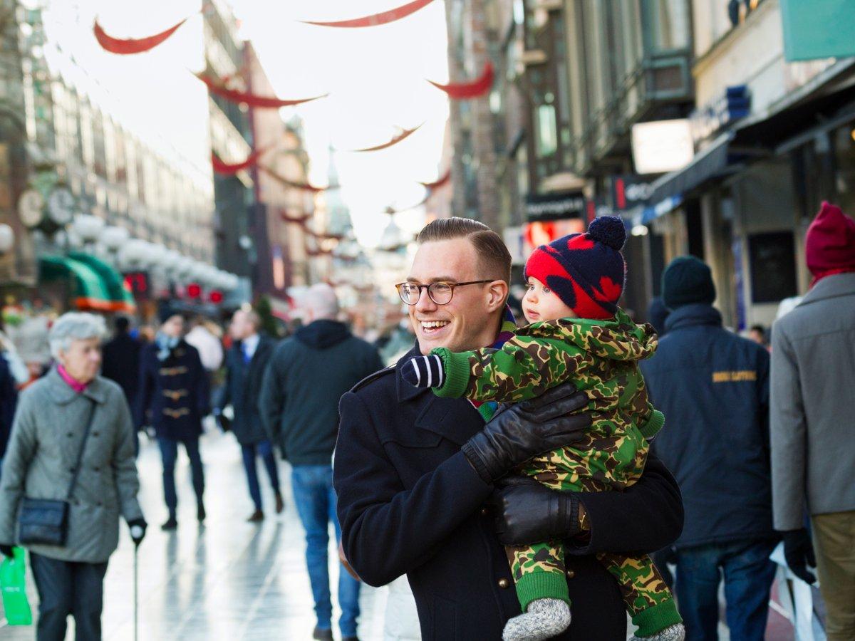 Bild på man och barn som tittar ut över gågata i Stockholm.