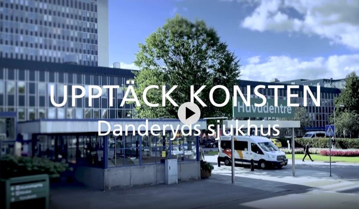 Filmruta av huvudentrén till Danderyds sjukhus med vit text över hela bilden Upptäck konsten Danderyds sjukhus.