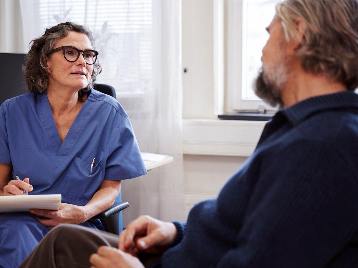 Bild på läkare som för samtal med en patient.