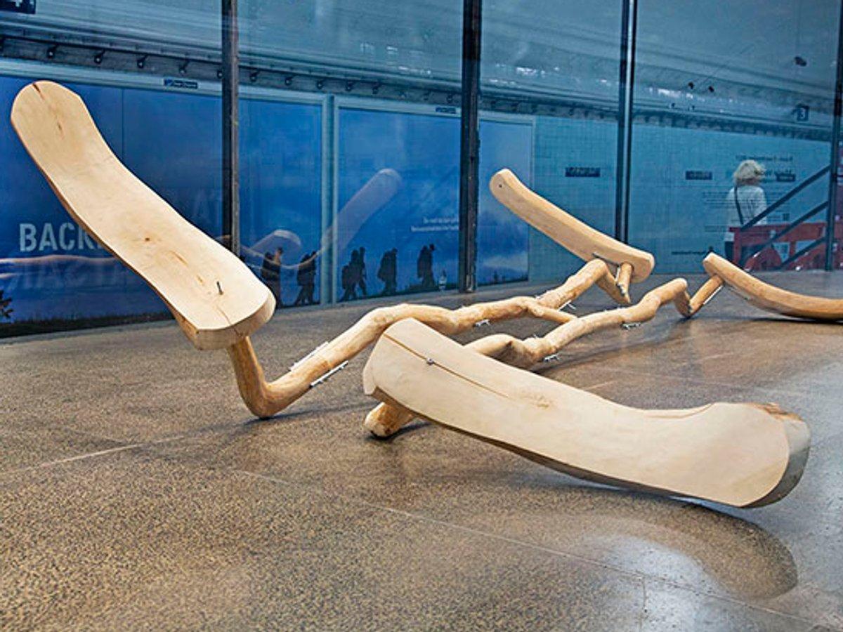 Träskulptur på golvet i montern. Formen för tankarna till en tång för tandvård.