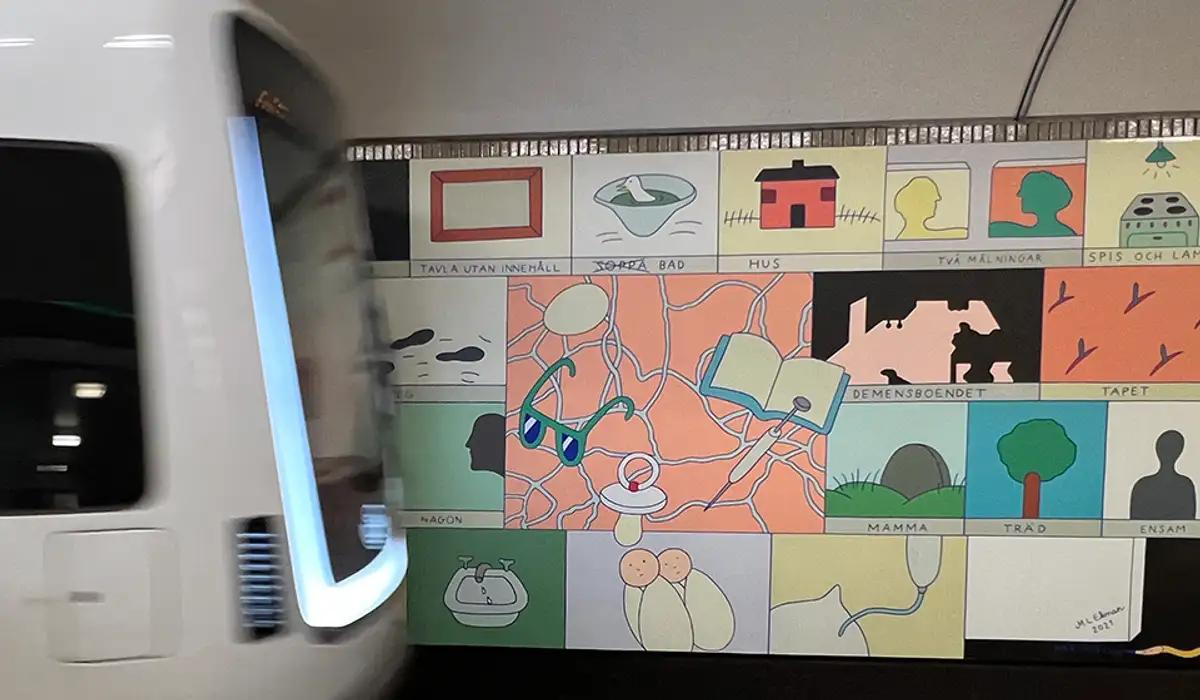 Tåg framför konst i tunnelbanan.