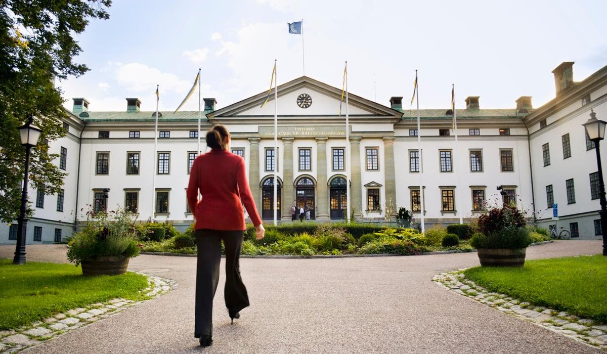 Kvinna klädd i röd kavaj går mot landstingshuset