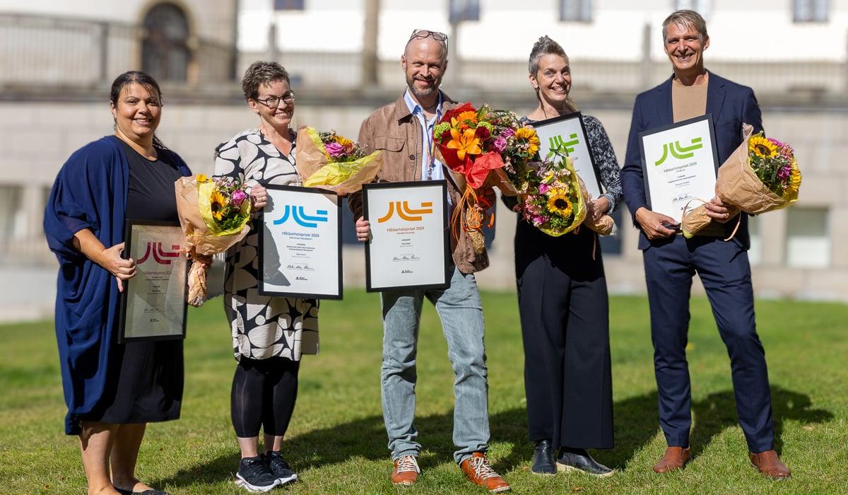 Foto på vinnarna av hållbarhetspriset. De håller i blommor och diplom