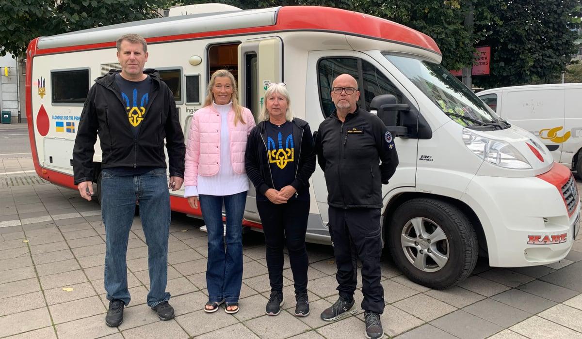 Foto på blodbussen som ska skänkas till Ukraina. Framför bussen står fler personer och tittar in i kameran. 