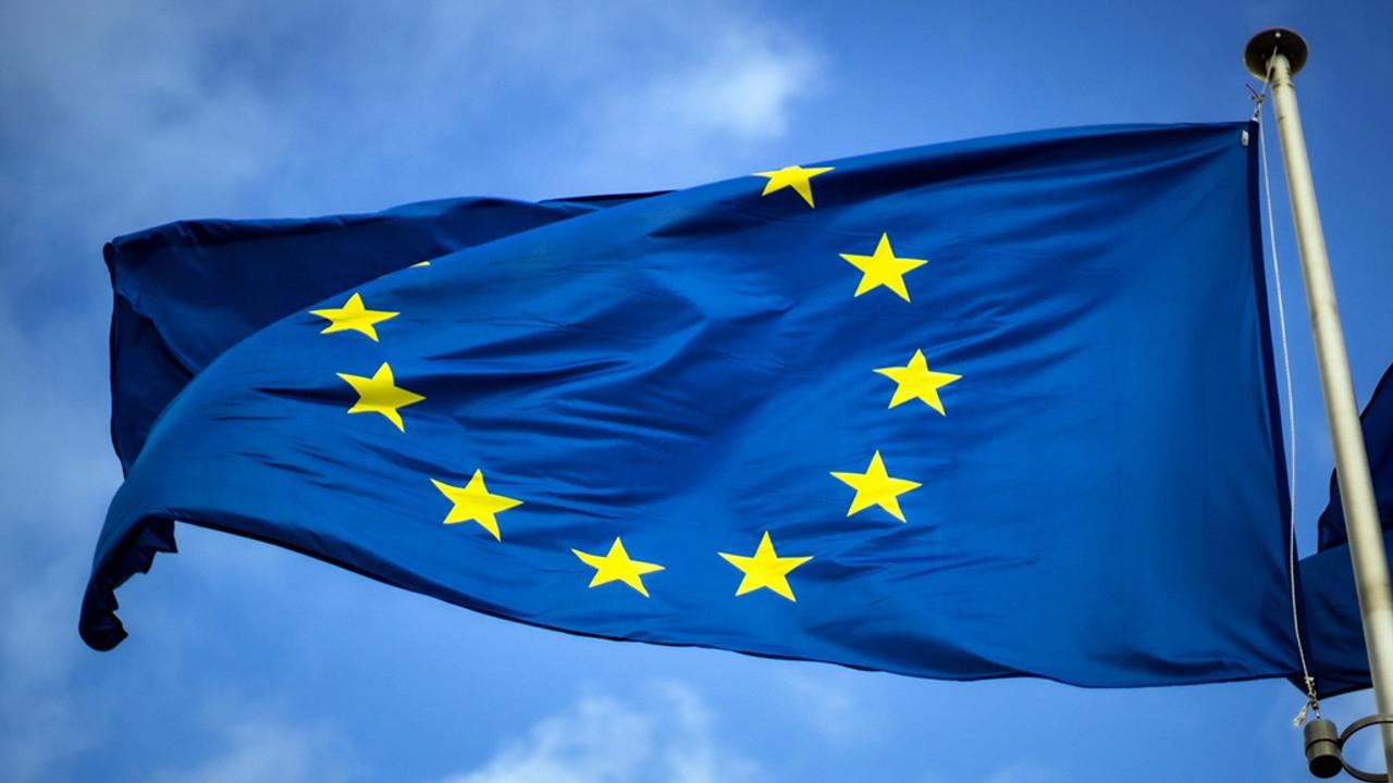 En EU-flagga vajrar med blå himmel i bakgrunden