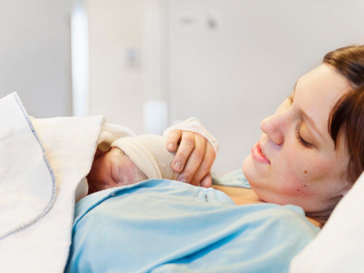 En kvinna håller i sitt nyfödda barn