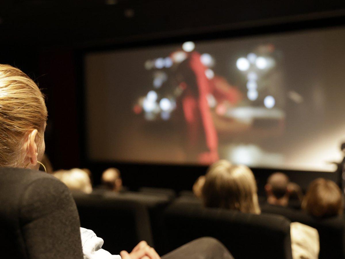 Personer som sitter i en biografsalong och tittar på film