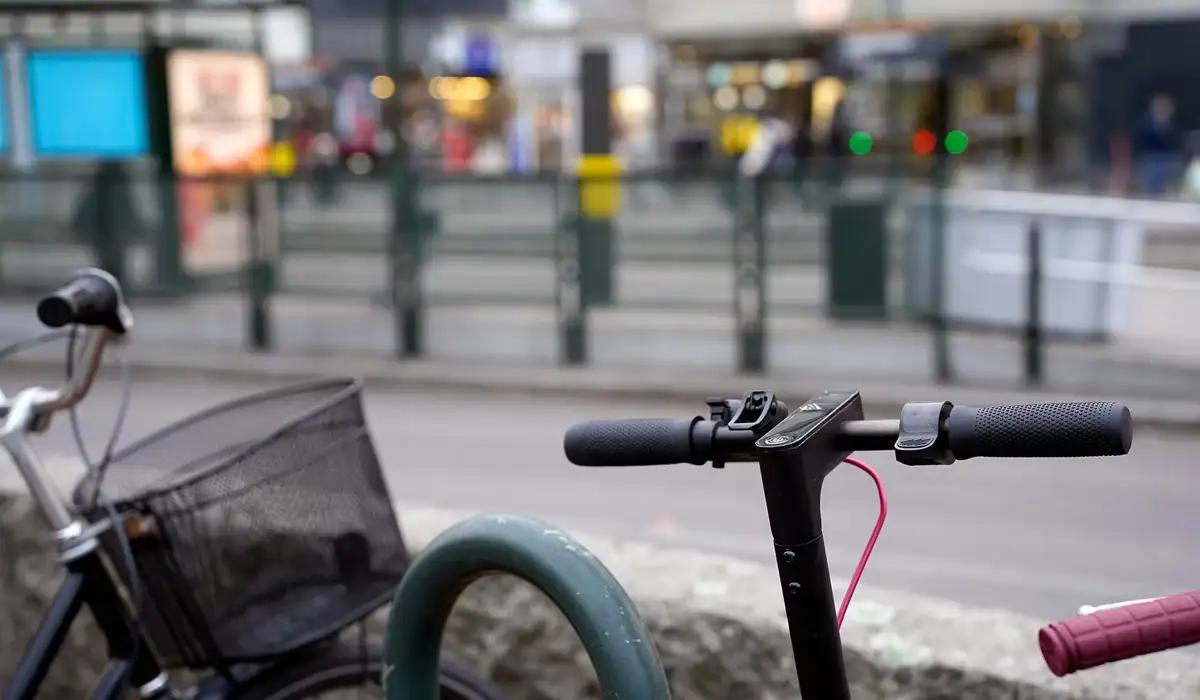 Cykel och elsparkcykel står parkerad i anslutning till hållplats på tvärbanan.