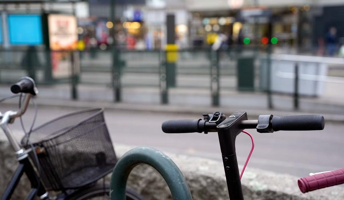 cykel och elsparkcykel står parkerad i anslutning till hållplats på tvärbanan. 