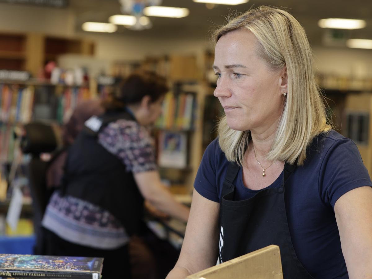 Två bibliotekarier i biblioteksmiljö.