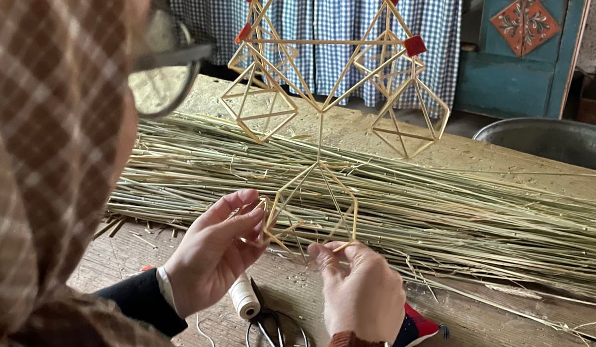 en person som slöjdar med halm