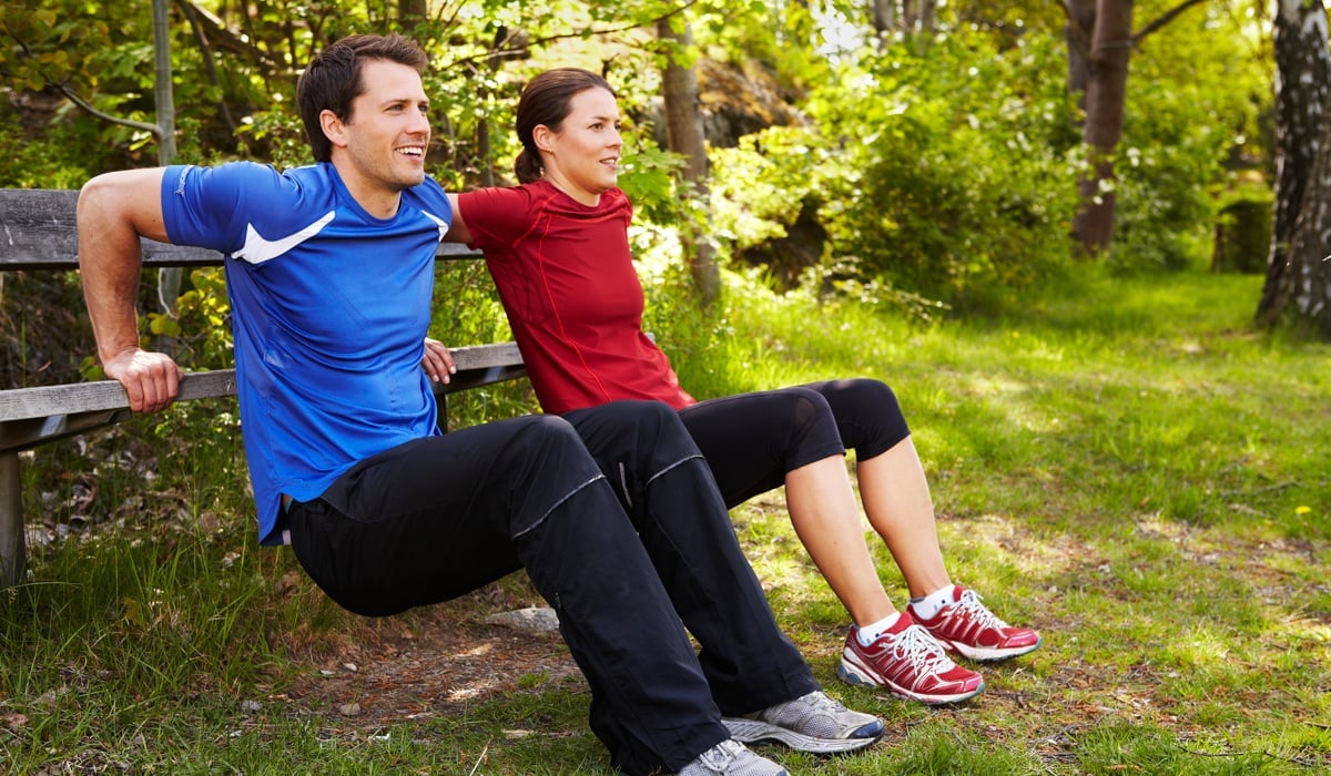 Bild på en man och en kvinna som tränar i naturmiljö.