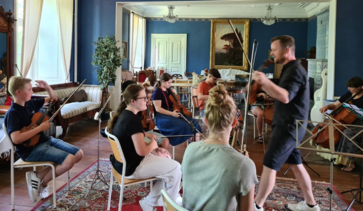 Ungdomar spelar musik framför en dirigent.