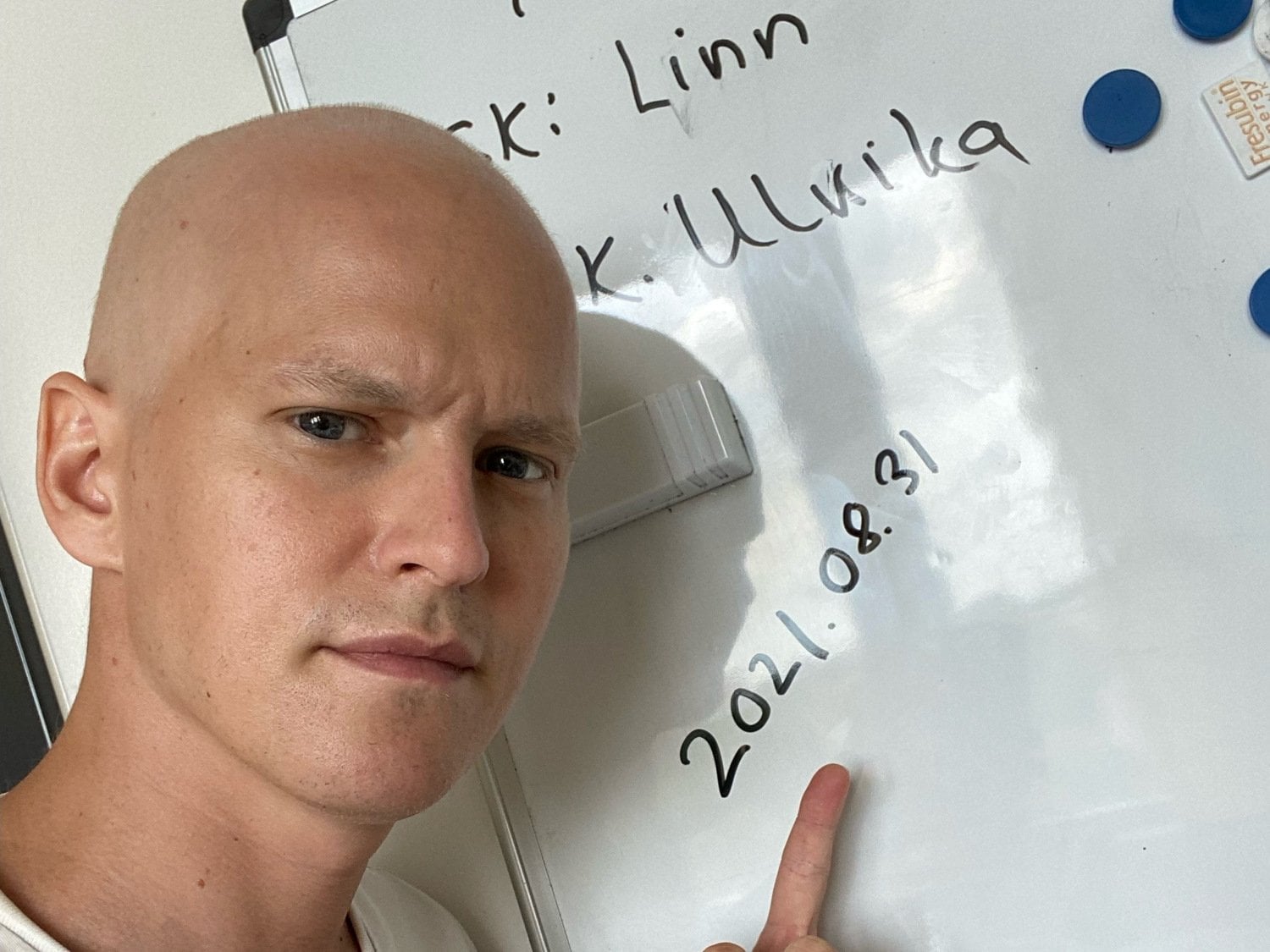 En person som står framför en tavla och pekar mot ett datum där det står 2021.08.31